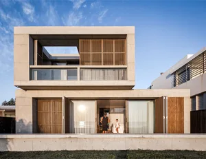 Modern residential building with concrete exterior and large glass windows.
