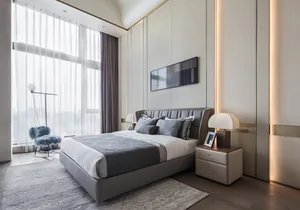 A modern bedroom featuring a textured fabric bed, minimalistic decor, and soft lighting.