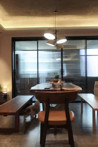A modern dining room featuring a flywood table, wooden furniture, and a cozy atmosphere.