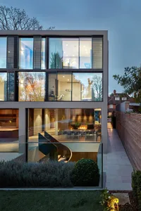 A modern interior with large glass walls, interior lighting, and a spacious layout.