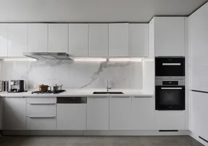 A sleek, modern kitchen with white marble countertops, white cabinets, and stainless steel appliances.