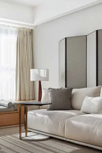 Modern living room featuring fabric sofa, wood coffee table, and glass divider