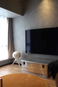 A modern living room featuring a metallic box and a large screen television.