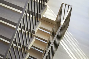 A modern wooden staircase with black metal railings.