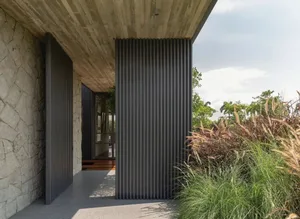 A modern entryway featuring metal cladding, stone and concrete materials.