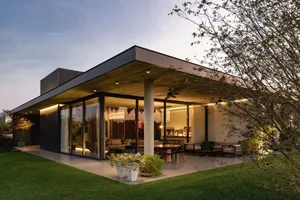 A modern house with a concrete exterior and glass walls.