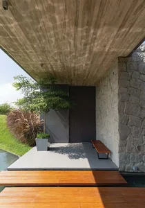 Modern minimalist exterior with concrete, stone, and wooden elements.