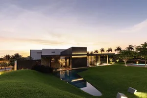 A modern residential exterior featuring metal, glass, and concrete elements.