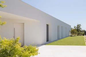 Minimalist white building with no windows on the facade.