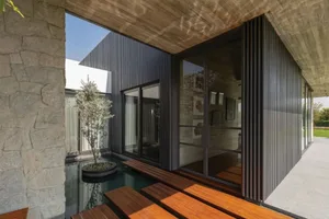 A minimalist architectural exterior featuring concrete and glass materials.