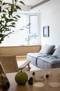Modern minimalist living room featuring neutral-toned fabric cushions on a low-profile sofa.