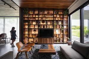A modern living room with wooden furniture and shelves filled with decorative items.