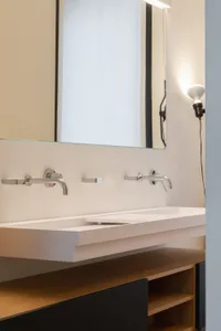 A modern bathroom with a concrete countertop and sink, featuring minimalist design elements.