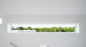 A modern window showcasing a landscape view of green trees and buildings through a long rectangular window.