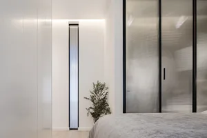 Modern minimalist bedroom featuring glass and metal elements.