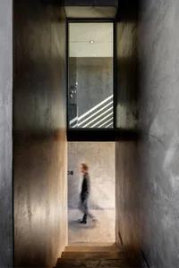 A minimalist, modern staircase with concrete walls.