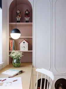 Modern, minimalist home office with shelves, books, and a birdhouse clock.