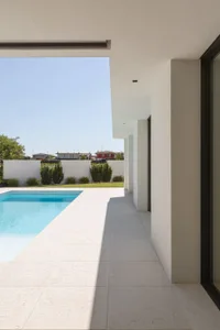 Modern minimalist residential exterior featuring white stone and concrete materials.