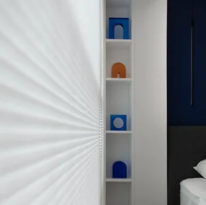 Modern bedroom with white minimalist shelves, blue and orange geometric objects, and a dark headboard.