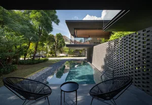Modern residential backyard with concrete and natural stone features.
