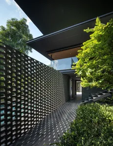 Modern building exterior featuring a metal lattice wall and lush greenery