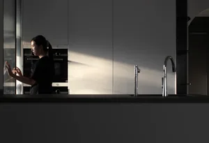 A minimalist kitchen with modern design elements such as glass and stainless steel