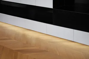 Modern living room featuring a wood floor with geometric patterns and white storage units.
