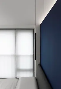 Modern minimalist bedroom featuring window blinds.