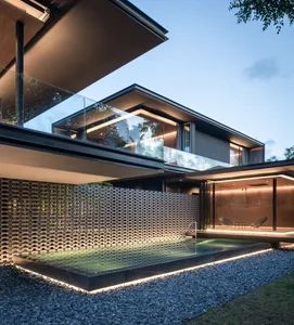 Modern minimalist house with a concrete exterior, swimming pool, and outdoor seating area at dusk.