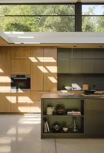 A modern minimalist kitchen with wooden cabinets and a steel island.