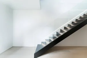 Metal stairs with glass railing in a minimalist interior space
