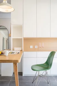 A modern white kitchen with wooden furniture and white cabinets.