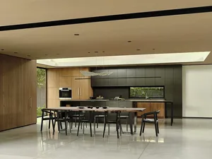 Large, open-plan, minimalist residential kitchen with black and white color scheme and metallic finishes.