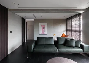 Modern living room with a sleek, leather couch, concrete walls, and minimalistic design.