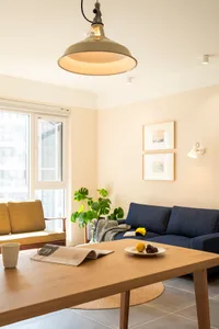 Modern, minimalist living room with wooden furniture, fabric upholstery, and metal accents.