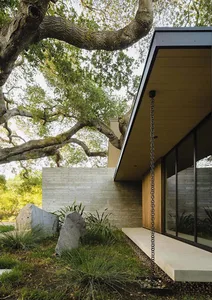 Modern residential exterior featuring concrete, wood, and glass materials
