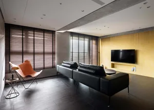 A modern contemporary leather sofa with dark wood flooring and built-in entertainment center, featuring industrial-style meta