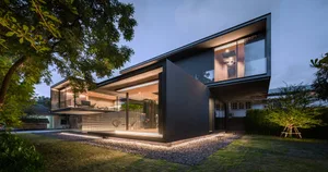 A modern house with a black metal exterior and large windows.
