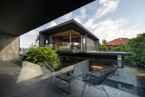 Modern living space featuring concrete walls and a glass wall.