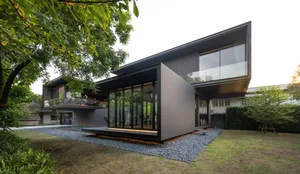 Modern minimalist house exterior with metal cladding and large glass windows.