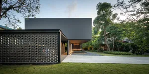 A modern house with a metal roof in a garden setting.