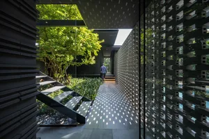 A modern interior design featuring a concrete garden hallway with a concrete staircase and a view of greenery through a glass