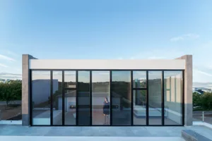 Modern residential building with large glass windows and minimalist design.