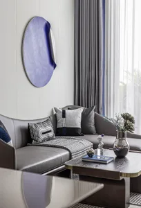 Modern living room featuring a stylish leather sofa, patterned throw pillows, and a minimalist coffee table.