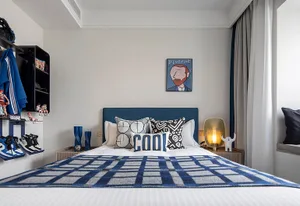 Modern bedroom featuring a white bed with blue and white checkered blanket and decorative pillows placed against a light gray