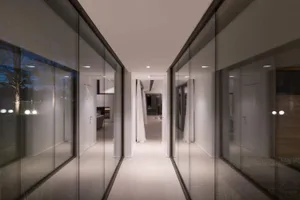 A modern hallway with glass walls and a long corridor.