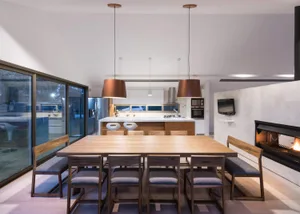 Modern residential interior with a wooden dining table and kitchen island