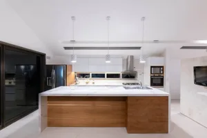 Modern residential kitchen featuring marble countertops, wooden cabinetry, and stainless steel appliances.