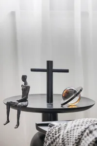 A minimalist interior design featuring a metallic shelf unit with abstract sculptures and a reflective globe.