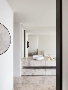 A bathroom featuring minimalist design with marble surfaces and a modern sink and faucet.